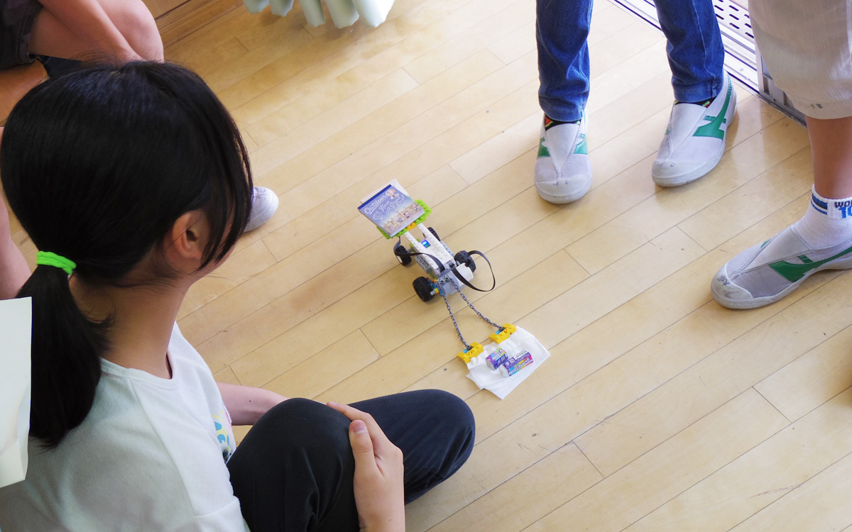 プログラミングがロボットの動きに反映されているか検証する児童