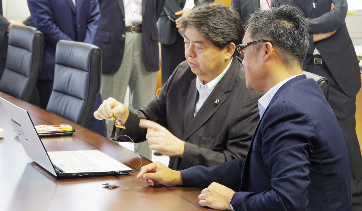 林芳正文部科学大臣(左)とWDLCの会長である梅田成二氏(右)。条件分岐によって「micro:bit」のLEDを点灯させるプログラミングを体験した。